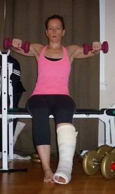 a woman is sitting on a bench with two dumbbells in front of her