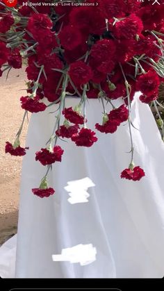 a bouquet of red flowers sitting on top of a white table