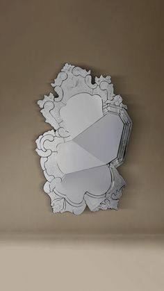 a decorative mirror hanging on the wall in a room with beige walls and flooring