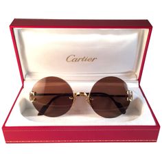 New Cartier Madison unique rimless sunglasses with brown (uv protection) lenses. Frame with special details on the front and sides in gold. All hallmarks. Cartier gold signs on the black ear paddles. These are like a pair of jewels on your nose. Please notice this pair may have minor sign of wear due to storage. Beautiful design and a real sign of the times. Amazing red leather original Cartier with real gold clips sleeve no hard case. 1990's designed and produced. 50mm medium size. Luxurious Sunglasses, Cartier Glasses, Eyes Glasses, Cartier Vintage, Cartier Gold, Glasses Trends, Cartier Sunglasses, Gold Glasses, Rimless Glasses