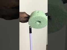 a person is using a toilet brush to clean the bathroom floor with a green towel