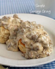 some biscuits covered in gravy on a white plate