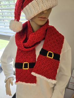 a mannequin wearing a red and white knitted scarf with santa's hat