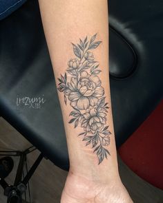 a woman's arm with a flower tattoo on it