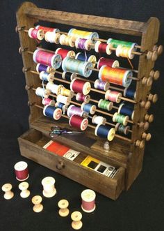 an old wooden sewing rack filled with spools of thread