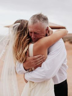 a man and woman embracing each other in the desert