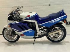 a blue and white motorcycle parked in a garage