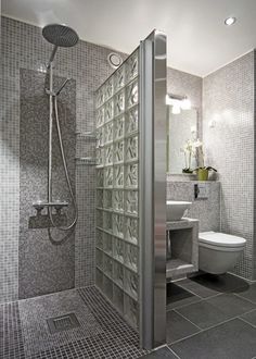 a bathroom with a shower, toilet and sink in the middle of tile flooring