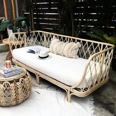 a wicker day bed with white cushions