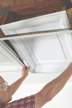 a man working on the ceiling in his home