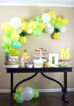 a table with balloons and pineapples on it