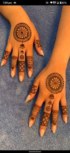 two hands with henna tattoos on them