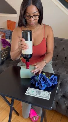 a woman sitting at a table with a wine glass and money in front of her