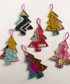 six handmade christmas tree ornaments hanging from strings