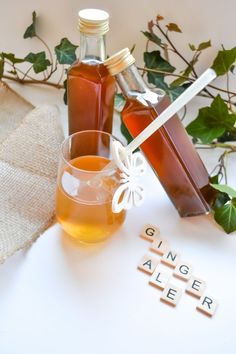 two bottles of honey sitting next to each other on top of a white tablecloth