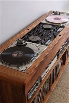 an old record player is sitting on top of a shelf with cd's in it