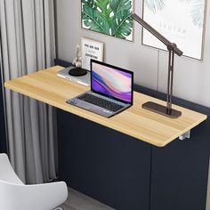 a laptop computer sitting on top of a wooden desk next to a lamp and chair