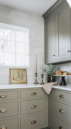 a kitchen with gray cabinets and gold handles