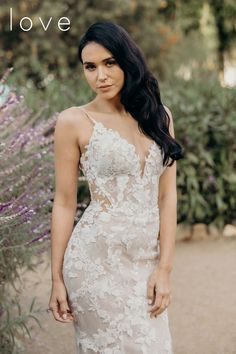 a woman in a wedding dress posing for a photo with lavender bushes behind her and the words love written on it