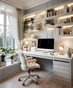 a white desk with a computer on it in front of a window and shelves filled with books