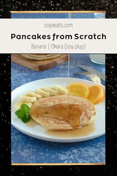 pancakes from scratch on a white plate with orange slices and syrup being drizzled over them