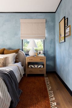 a bed room with a neatly made bed and a window