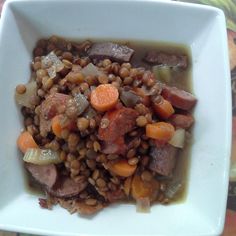 a white bowl filled with meat and vegetables