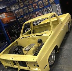 an old yellow truck is parked in a garage