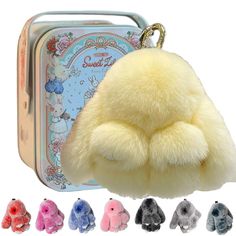 a small stuffed animal in front of a tin case with keychain and various colors