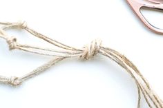 scissors and twine on a white surface next to each other, with one pair of pink scissors in the foreground