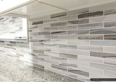 a kitchen counter with gray and white tiles on it's backsplashes