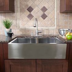 a stainless steel sink in a kitchen with wooden cabinets