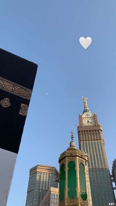 a tall building with a clock on it's side in front of other buildings