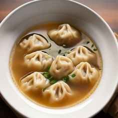 some dumplings are in a white bowl on a table