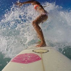 a woman riding a surfboard on top of a wave