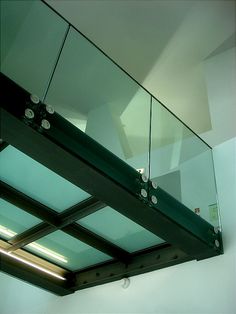 the glass railing is attached to the ceiling