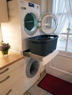 a washer and dryer are stacked on top of each other in front of a window