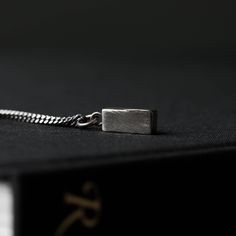 Men's Necklace Block Pendulum Pendant Handmade in Sterling SilverA captivating blend of elegance and authenticity crafted in oxidized sterling silver, enriched with the essence of Wabi Sabi philosophy.Inspired by the Japanese aesthetic of Wabi Sabi, this pendulum embodies the beauty found in imperfection and impermanence. Each piece is meticulously oxidized to enhance its unique character, resulting in a rich patina that tells a story of time and wear.The simplicity of the bar design reflects the minimalist elegance of Wabi Sabi, while the sterling silver construction adds a touch of sophistication. Whether worn as a pendant or used for divination, this pendulum serves as a reminder to embrace the beauty of life's imperfections and cherish the fleeting moments of beauty.Small yet striking, Wabi Sabi Philosophy, Oxidized Necklace, Japanese Aesthetic, Men's Necklace, Oxidized Sterling Silver, Bar Design, Bar Necklace, Modern Rustic, Wabi Sabi