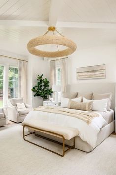 a bedroom with white walls and carpeted flooring has a large bed in the center