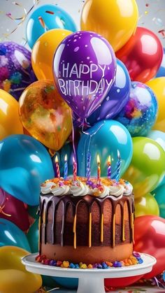 a birthday cake with candles and balloons in the background