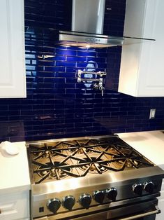 a stove top oven sitting inside of a kitchen next to a wall mounted range hood