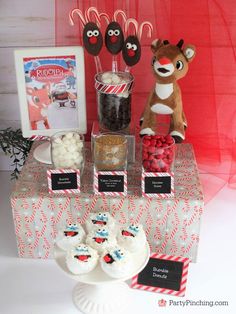 a table topped with lots of candy and candies next to a stuffed animal toy