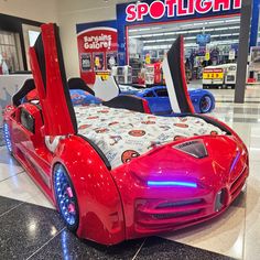 a red car shaped bed in the middle of a store