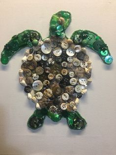 a sea turtle made out of buttons and other things on the wall in front of it