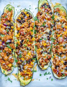 three stuffed zucchini boats on a baking sheet