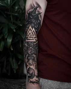 a man with a black and grey tattoo on his arm