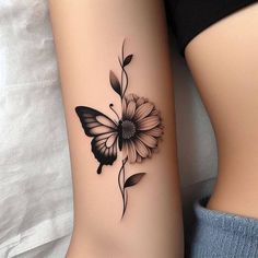 a black and white flower tattoo on the right side of the leg, next to a butterfly