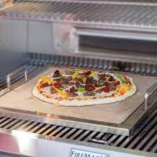 a pizza sitting on top of a metal tray in a kitchen next to an oven