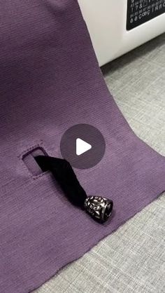 a video demonstrating how to sew on the back of a purple piece of fabric