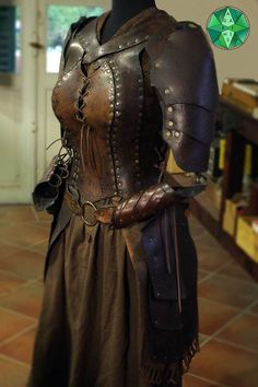 a mannequin dressed in brown leather with chains and armor on it's arms